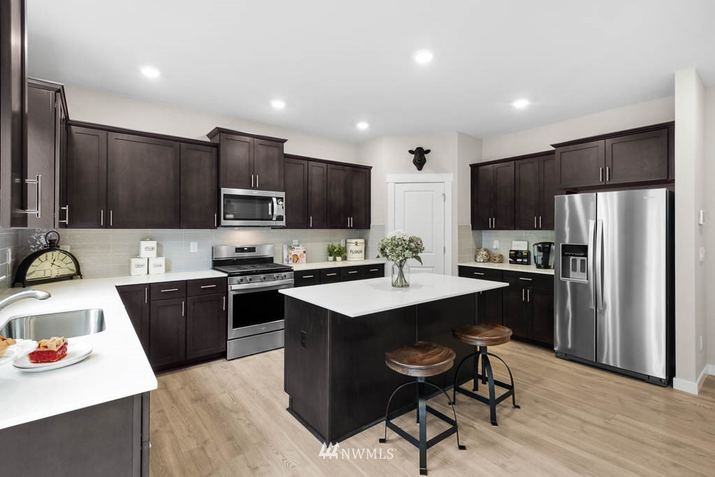 26 180th Place Southwest, Unit 25 Bothell, WA 98012 - Photo 11 of 39 a kitchen with kitchen island a sink stove and refrigerator