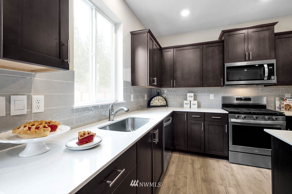 26 180th Place Southwest, Unit 25 Bothell, WA 98012 - Photo 15 of 39 a kitchen with stainless steel appliances granite countertop a sink and stove