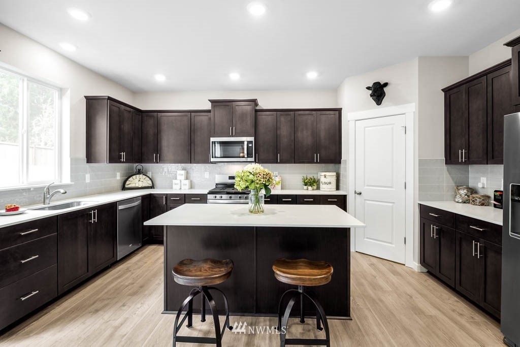 26 180th Place Southwest, Unit 25 Bothell, WA 98012 - Photo 10 of 39 a kitchen with kitchen island a stove a sink a refrigerator a dining table and chairs