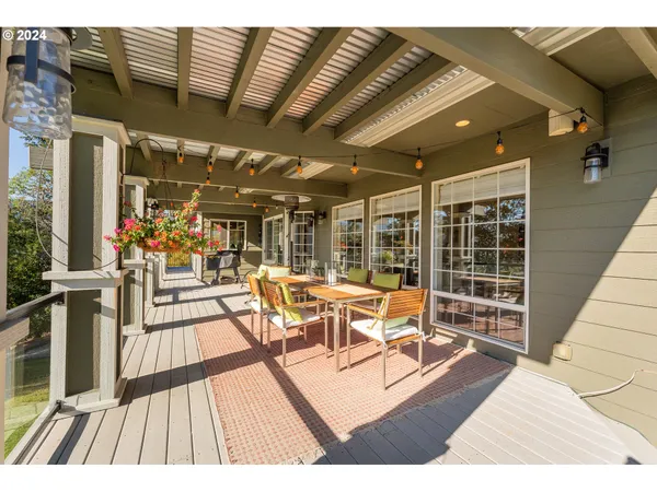 a view of a patio with dining table and chairs with wooden floor