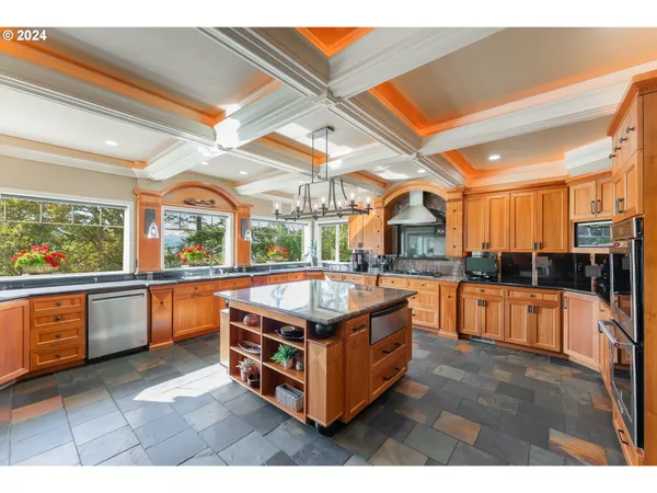 a kitchen with stainless steel appliances granite countertop a stove a sink and a wooden floors