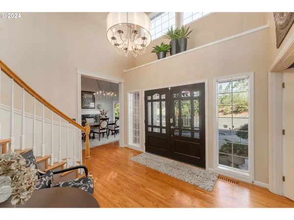 a view of a hallway with a dining table and a chandelier