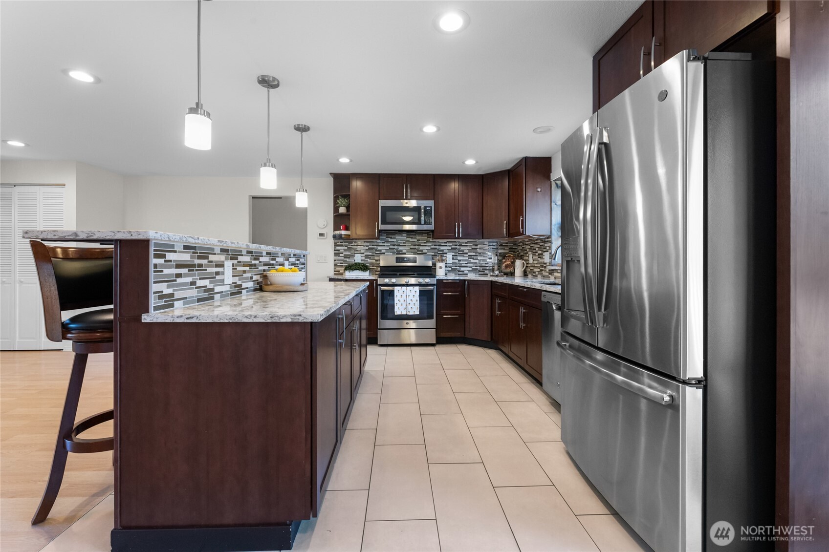 25847 185th Place Southeast Covington, WA 98042 - Photo 8 of 17 a kitchen with stainless steel appliances granite countertop a refrigerator a stove a sink and a microwave