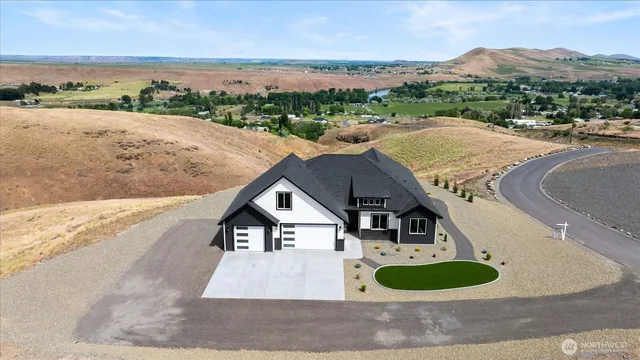 an aerial view of a house with a yard and ocean view