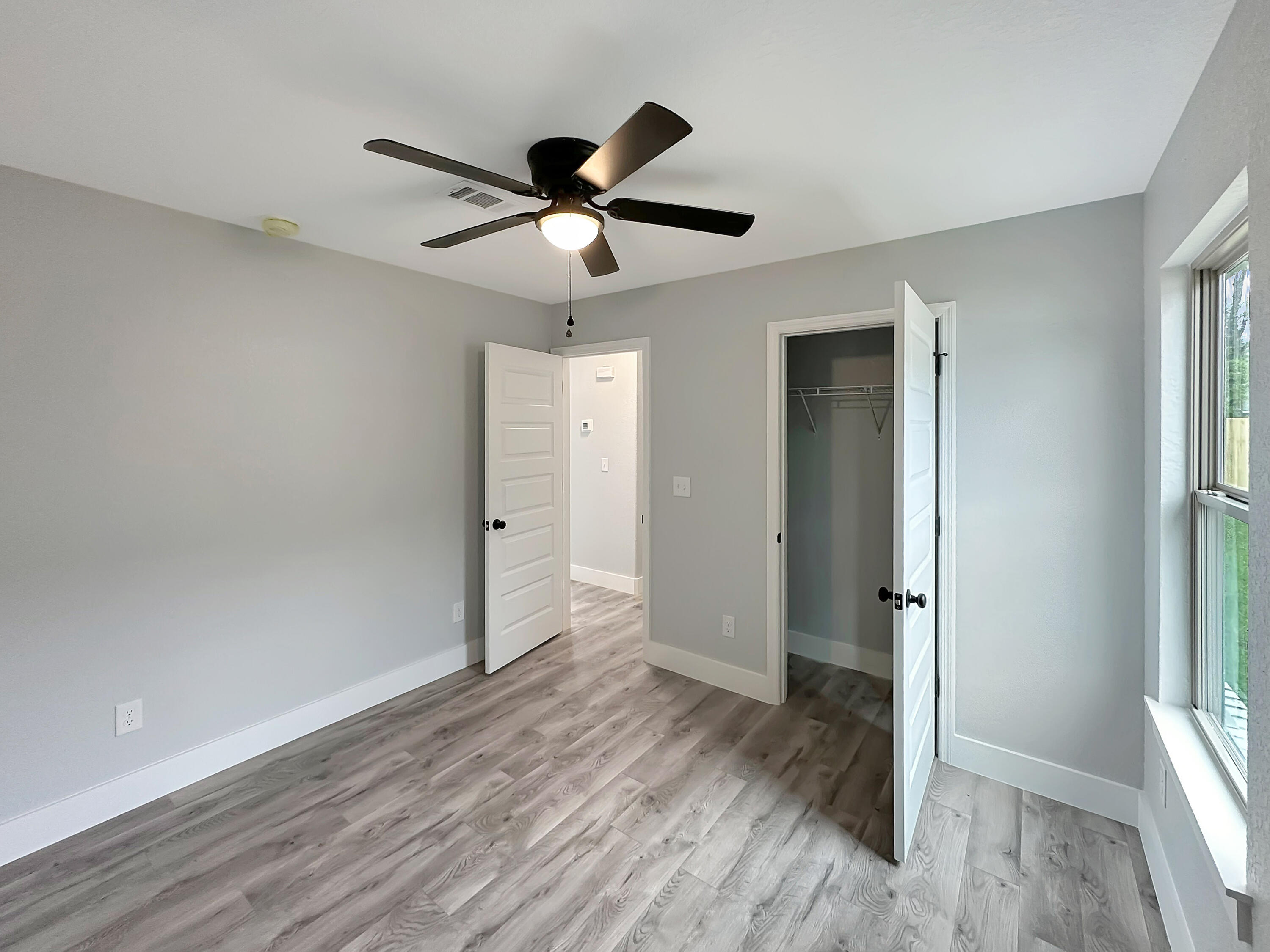5771 Monroe Street Baker, FL 32531 - Photo 12 of 23 a view of empty room with wooden floor and fan