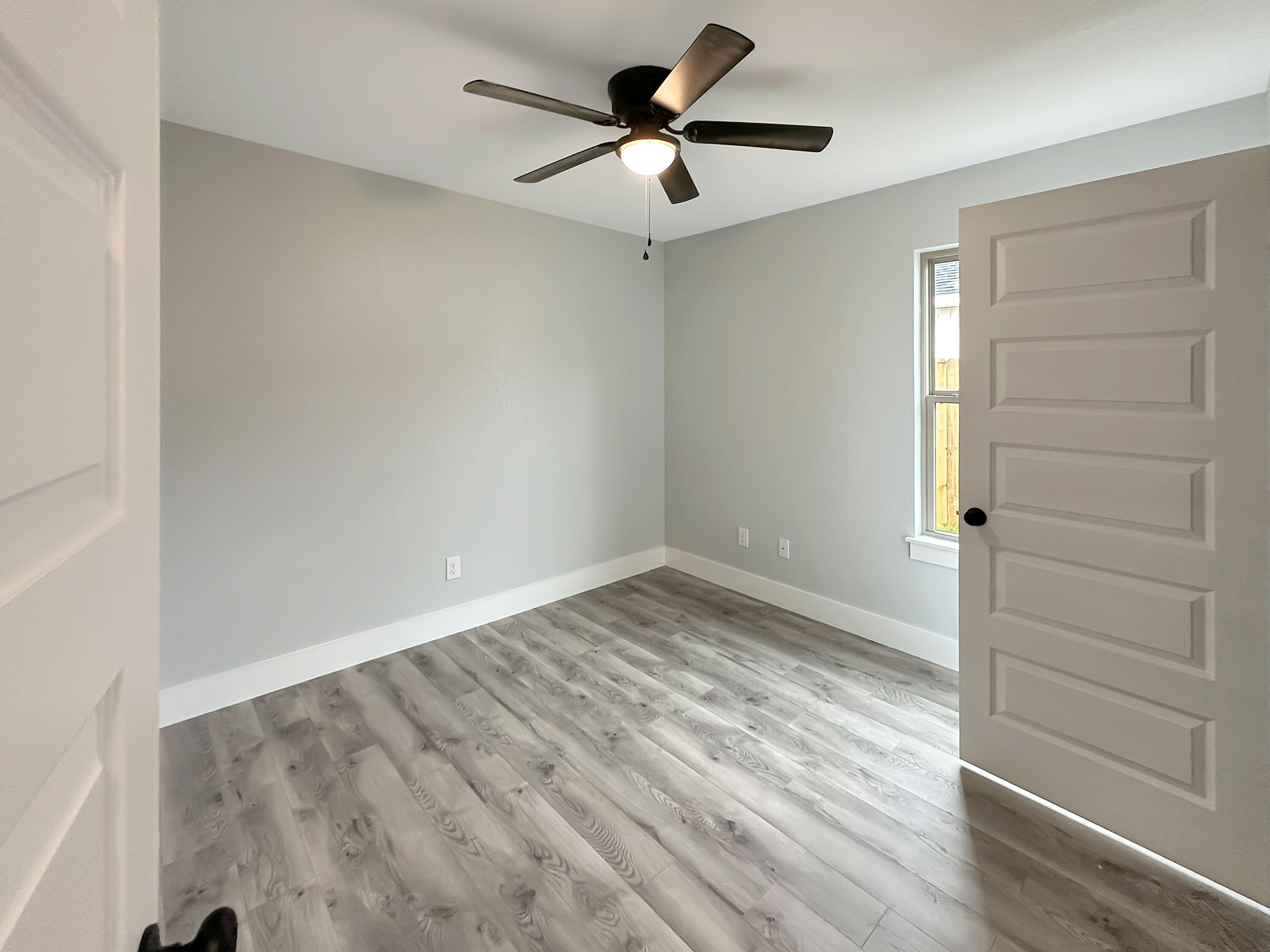 5771 Monroe Street Baker, FL 32531 - Photo 13 of 23 an empty room with wooden floor chandelier fan and windows