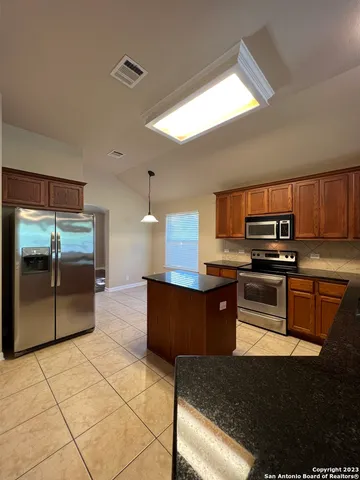 a kitchen with stainless steel appliances granite countertop a stove a sink and a refrigerator