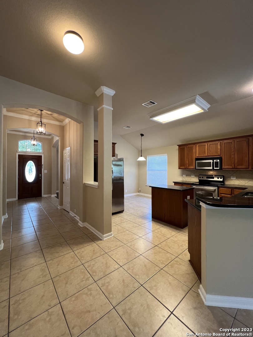 24431 Flint Creek San Antonio, TX 78255 - Photo 12 of 45 a view of a kitchen with kitchen island granite countertop a refrigerator and a stove top oven