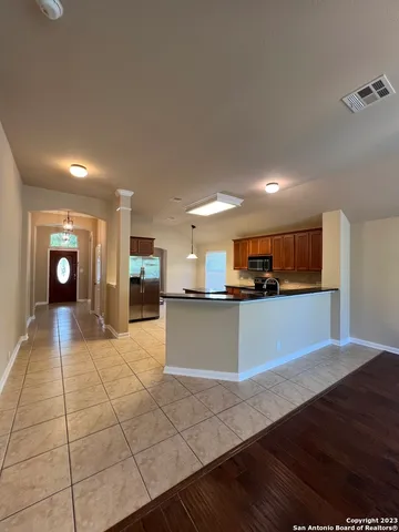a large kitchen with stainless steel appliances a large counter top a stove and a refrigerator