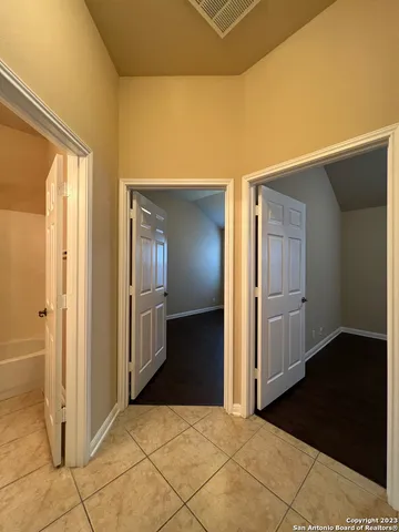 a view of a hallway with wooden floor and cabinet