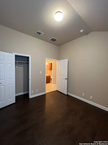 an empty room with wooden floor and closet