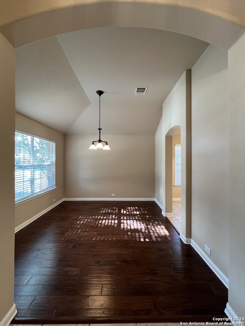 24431 Flint Creek San Antonio, TX 78255 - Photo 3 of 45 a view of an empty room with wooden floor fridge and a window