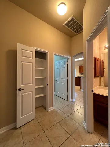 a view of a hallway with wooden shelves