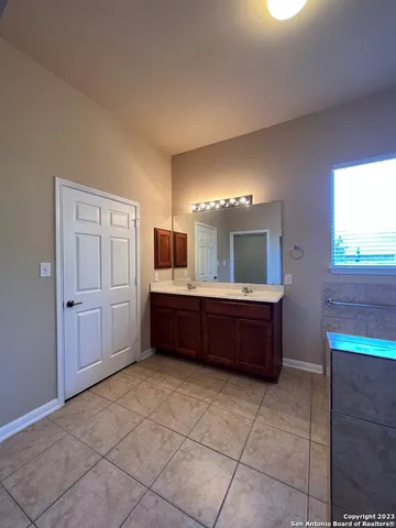 a bathroom with a tub a sink and a mirror