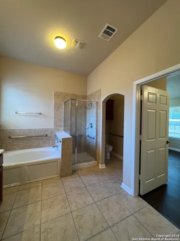 a bathroom with a tub shower and mirror
