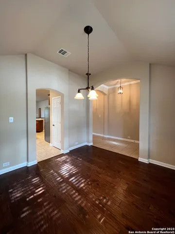 a view of a room with a ceiling fan and wooden floor