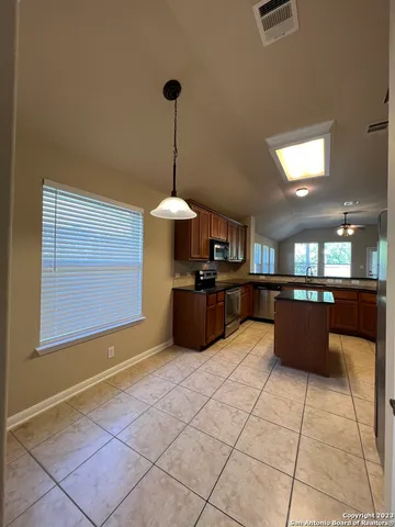 a large kitchen with stainless steel appliances kitchen island granite countertop a sink counter space and a view of kitchen