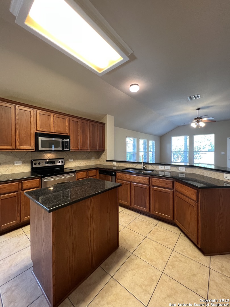 24431 Flint Creek San Antonio, TX 78255 - Photo 10 of 45 a kitchen with stainless steel appliances granite countertop a stove a sink dishwasher and a refrigerator