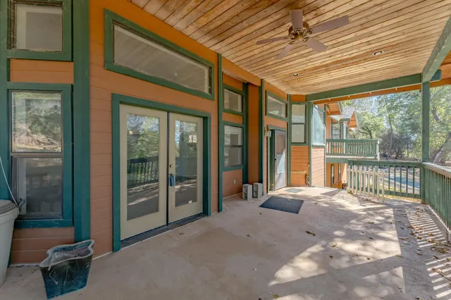 a large kitchen with stainless steel appliances wooden floor and a large window