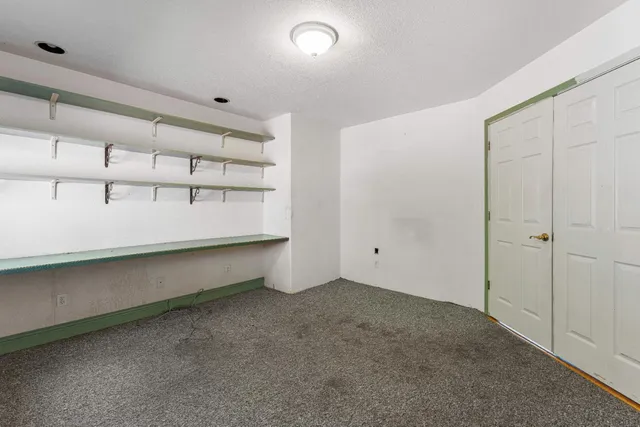 an empty room with fan and windows