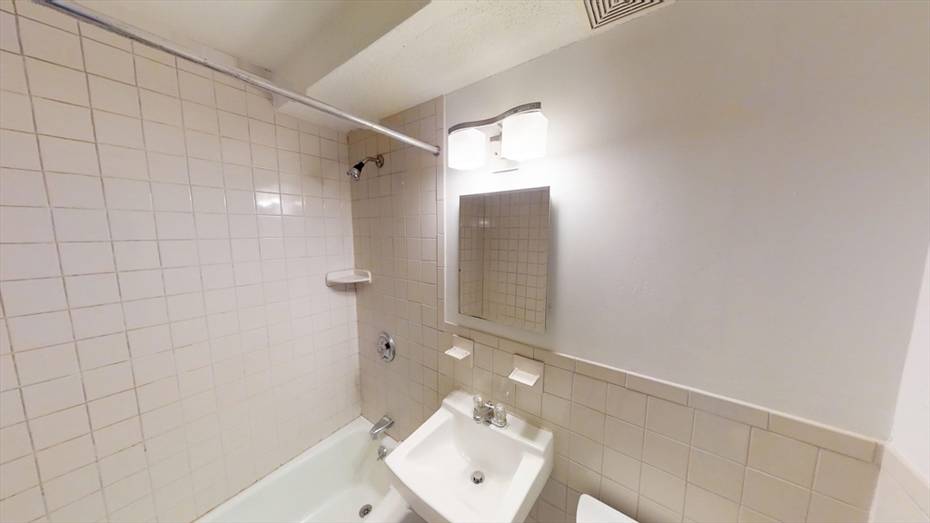 14 Murdock Street, Unit 17 Somerville, MA 02145 - Photo 5 of 12 a bathroom with a sink mirror and shower