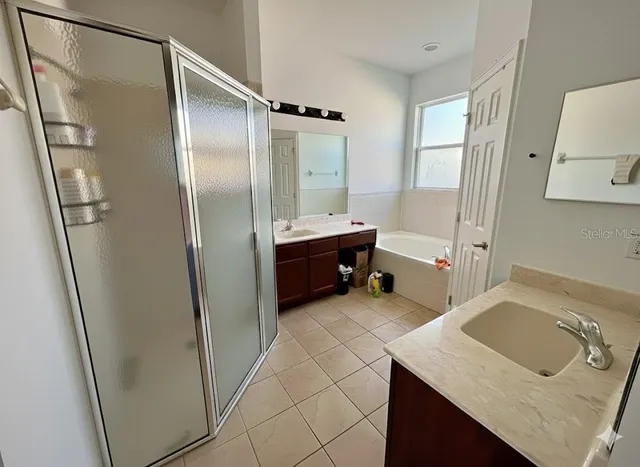 a bathroom with a tub sink and mirror