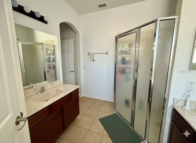 a bathroom with a double vanity sink a mirror and shower