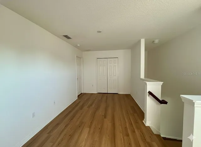 a view of empty room with wooden floor