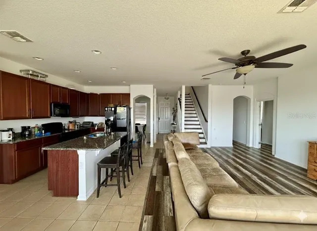 a kitchen with lots of appliances a sink a counter top space cabinets and stainless steel appliances