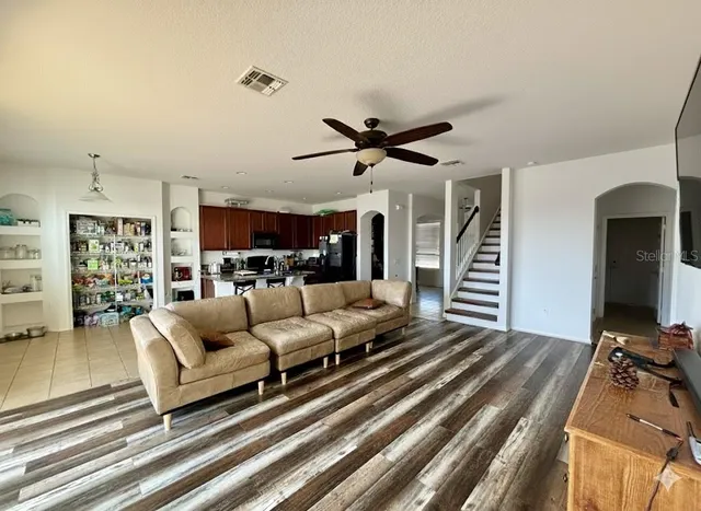 a living room with furniture ceiling fan and a rug