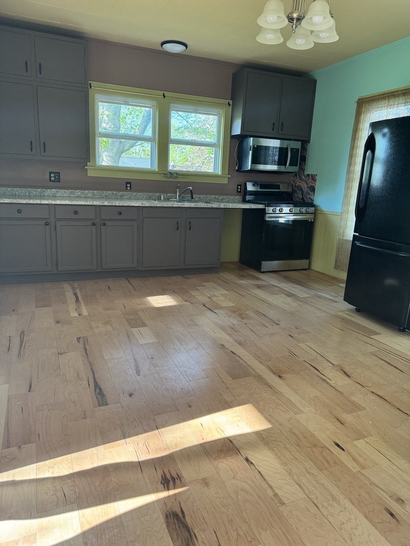 410 3rd Street Mendota, IL 61342 - Photo 7 of 18 a large kitchen with granite countertop a refrigerator and a stove