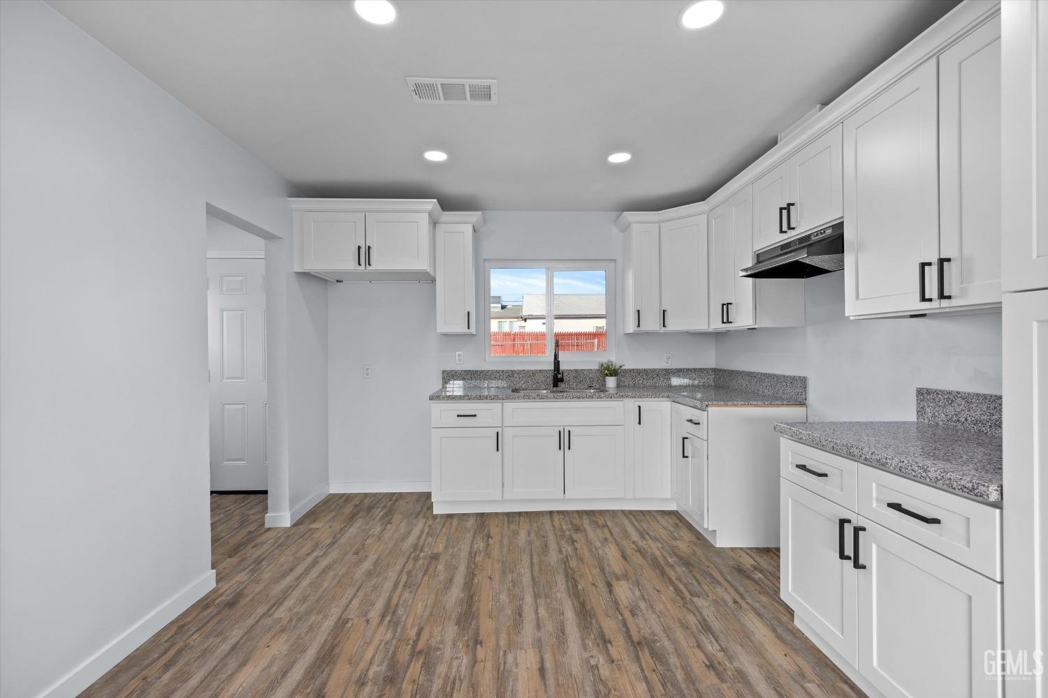 Undisclosed Address Bakersfield, CA 93306 - Photo 11 of 29 a kitchen with granite countertop white cabinets and white appliances