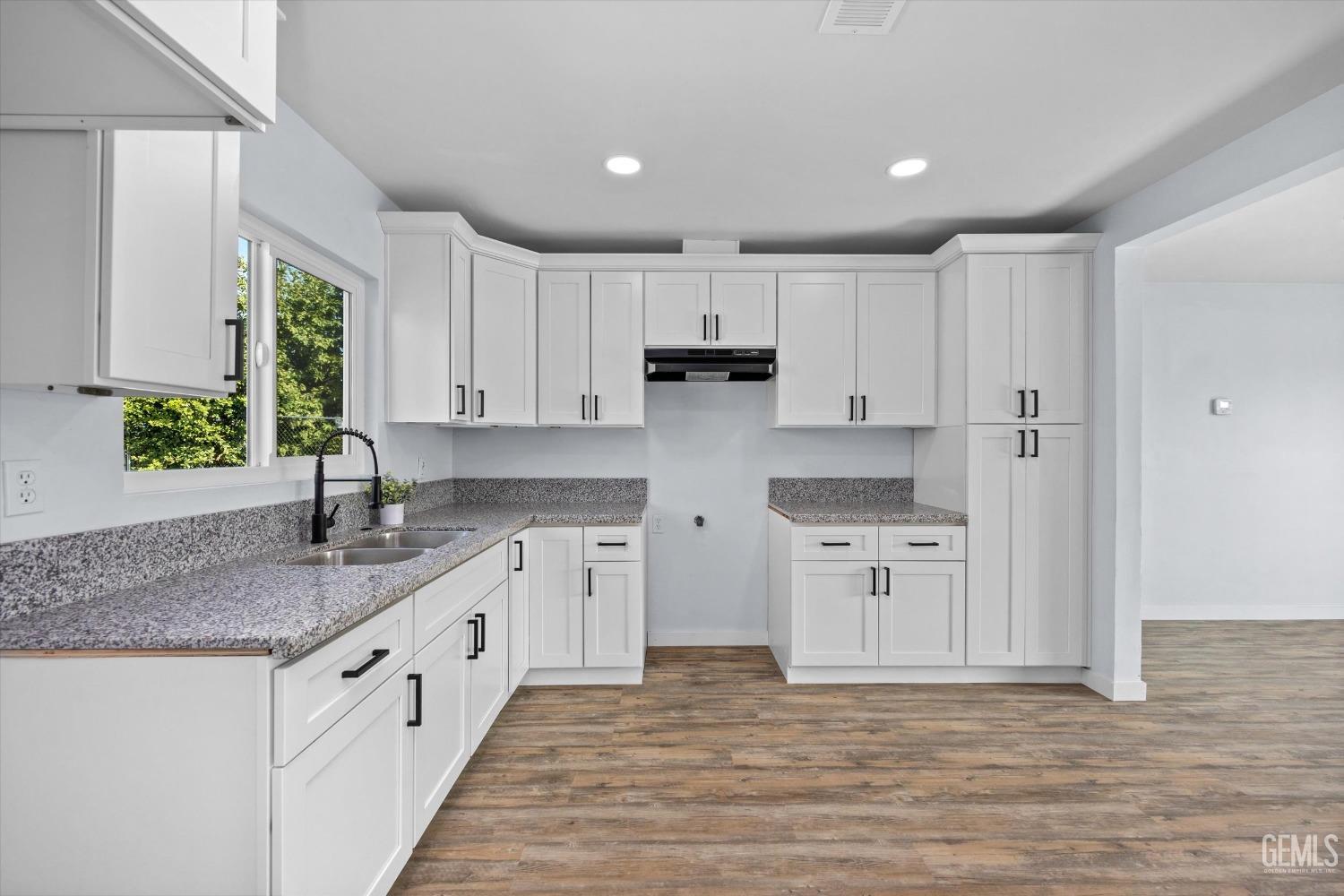Undisclosed Address Bakersfield, CA 93306 - Photo 13 of 29 a kitchen with granite countertop a sink stove and cabinets