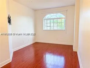 an empty room with a window and a ceiling fan