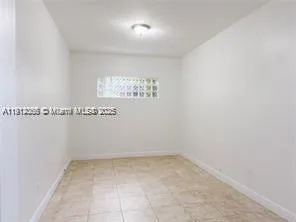 a view of an empty room with floor to ceiling window and an outdoor view