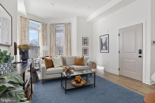 a living room with furniture kitchen view and a chandelier