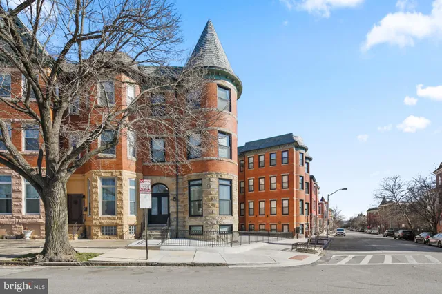 a view of a brick building next to a road
