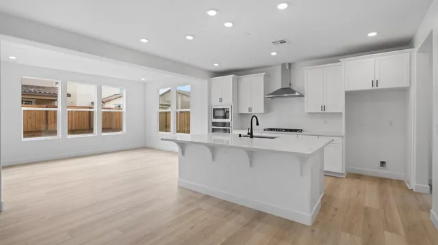 a kitchen with stainless steel appliances granite countertop a stove a sink and a refrigerator