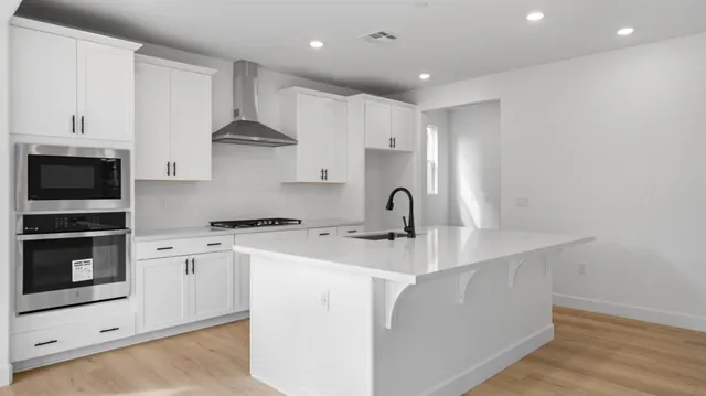 a kitchen with a sink a stove and cabinets