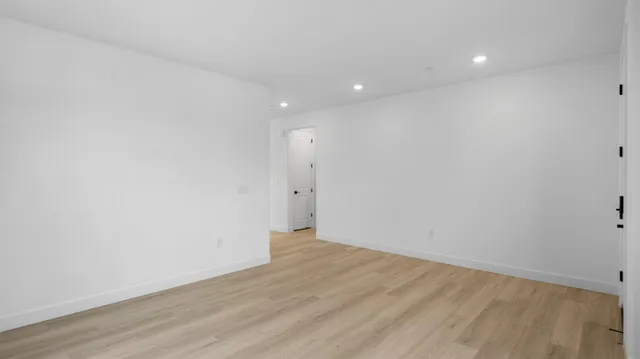 a view of an empty room with wooden floor
