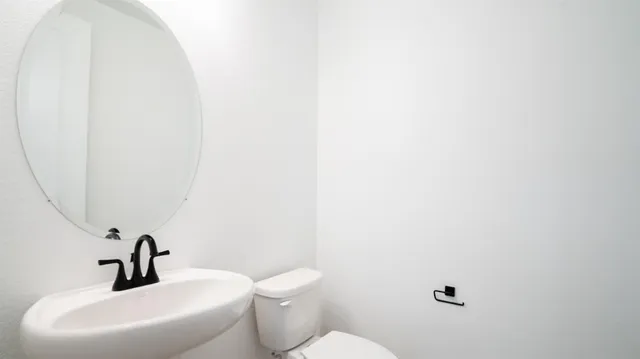 a bathroom with a toilet sink and mirror