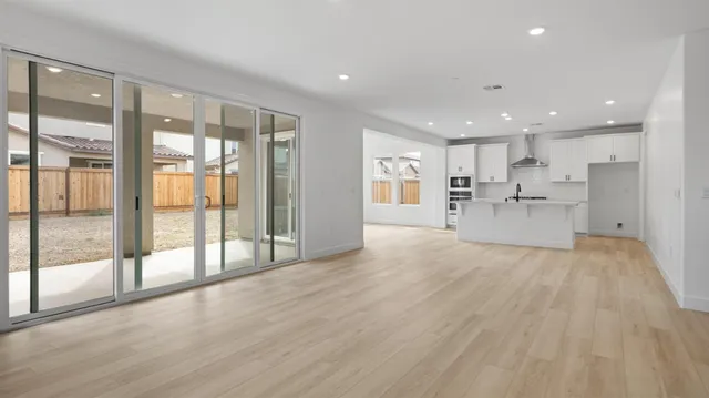 a view of a kitchen with large windows and a living room