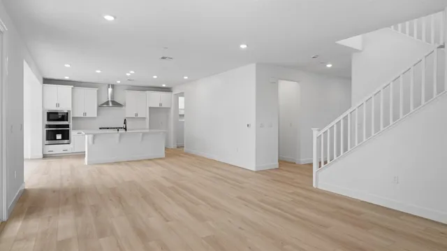 a view of kitchen with wooden floor and electronic appliances
