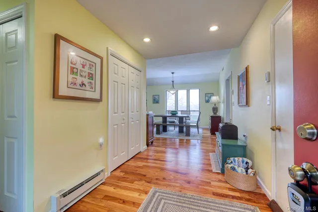 a living room with furniture and a dining table with wooden floor