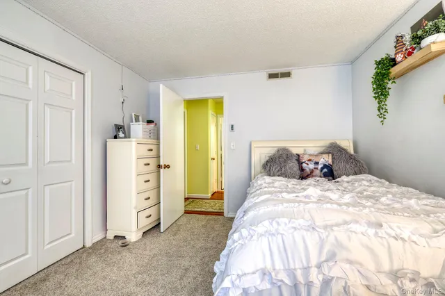 a bedroom with a bed and a refrigerator