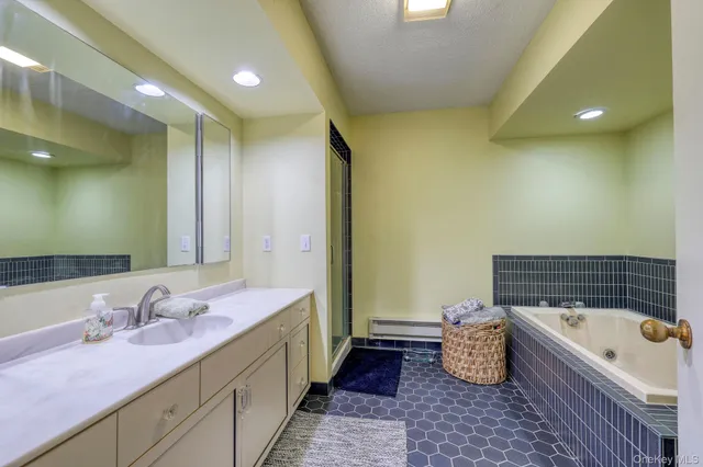 a bathroom with a tub sink and mirror