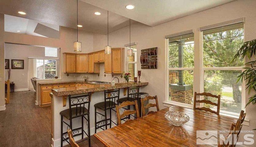 5001 Fall Colors Court Reno, NV 89519 - Photo 15 of 36 a kitchen with granite countertop a stove a sink a dining table and chairs with wooden floor
