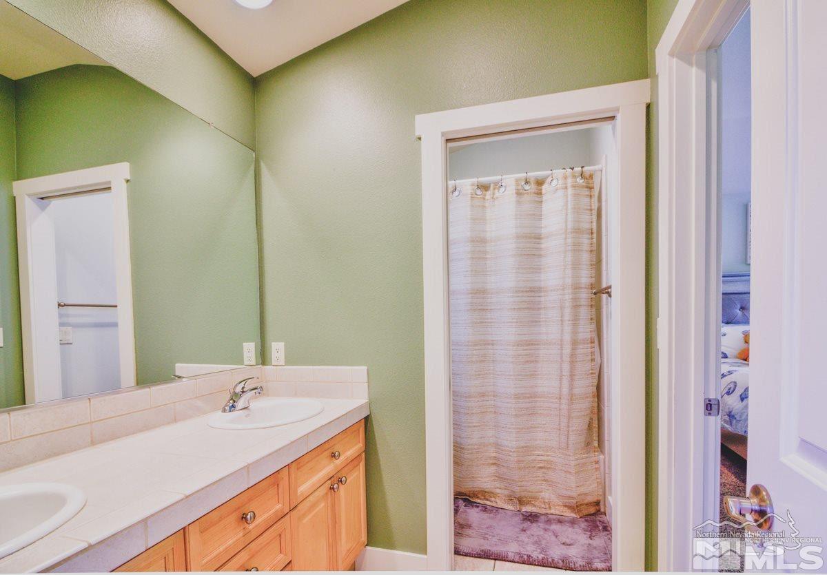 5001 Fall Colors Court Reno, NV 89519 - Photo 24 of 36 a bathroom with a granite countertop sink and a mirror