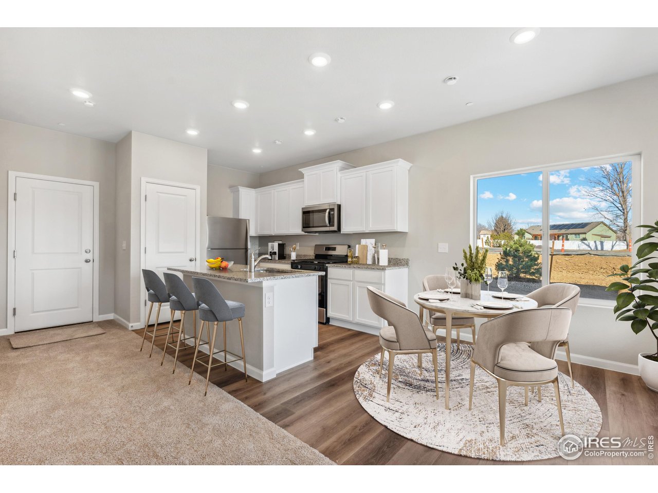 127 Robin Road Johnstown, CO 80534 - Photo 5 of 24 a kitchen with a dining table chairs and view living room
