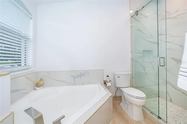 a bedroom with a bed and a flat tv screen on dresser